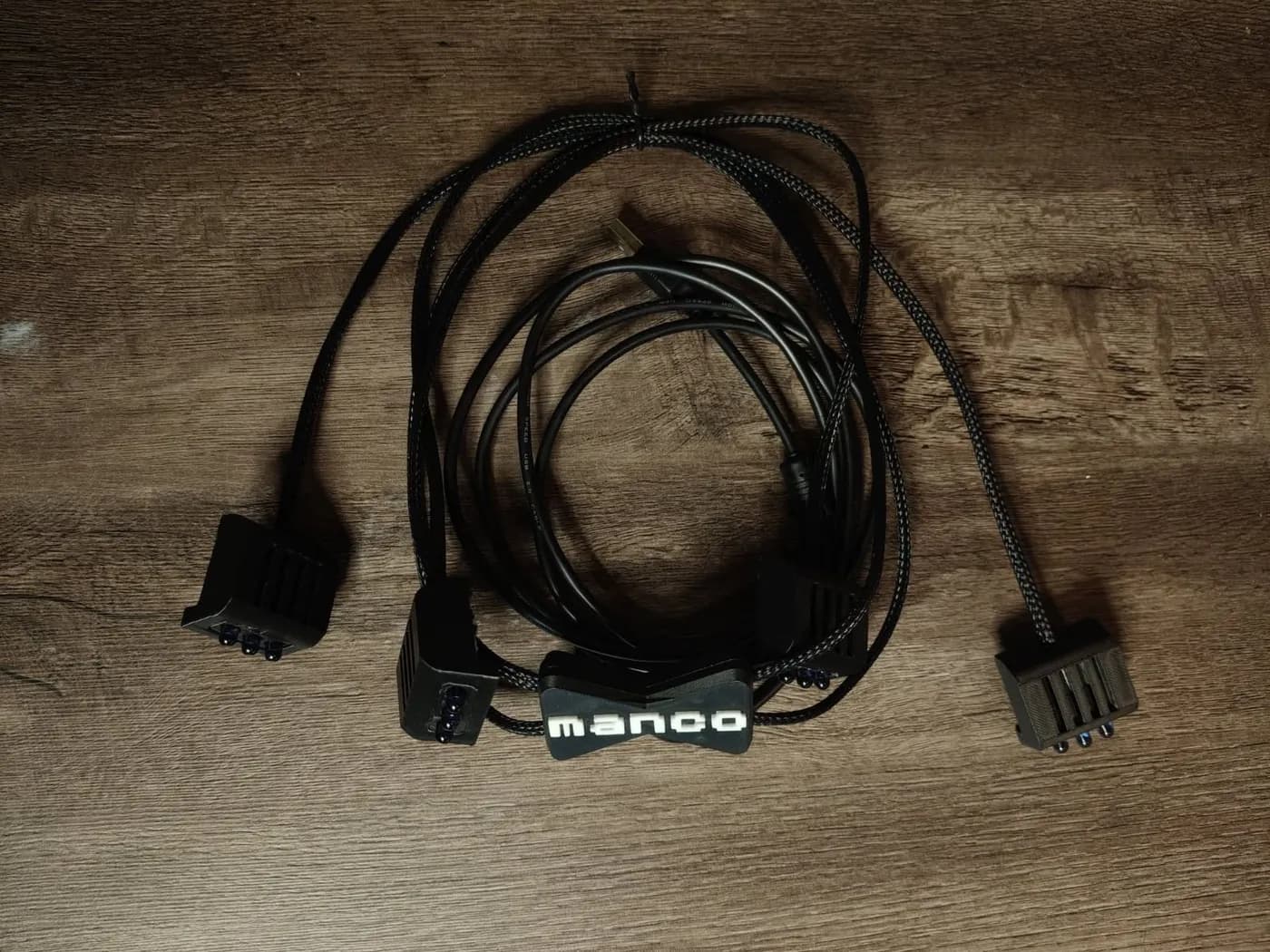 El módulo IR sobre una mesa: cuatro emisores negros unidos por cables trenzados, con una pieza que dice «manco».