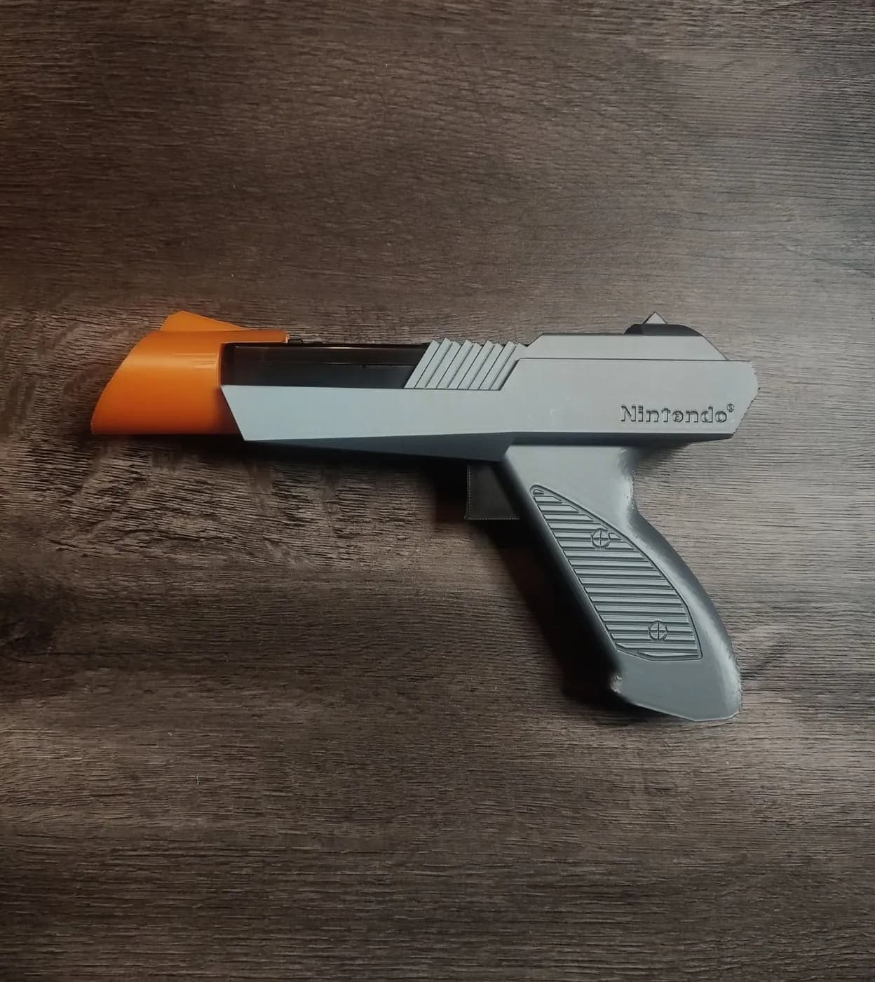 La carcasa Zapper, gris con la punta naranja, sobre una mesa de madera.